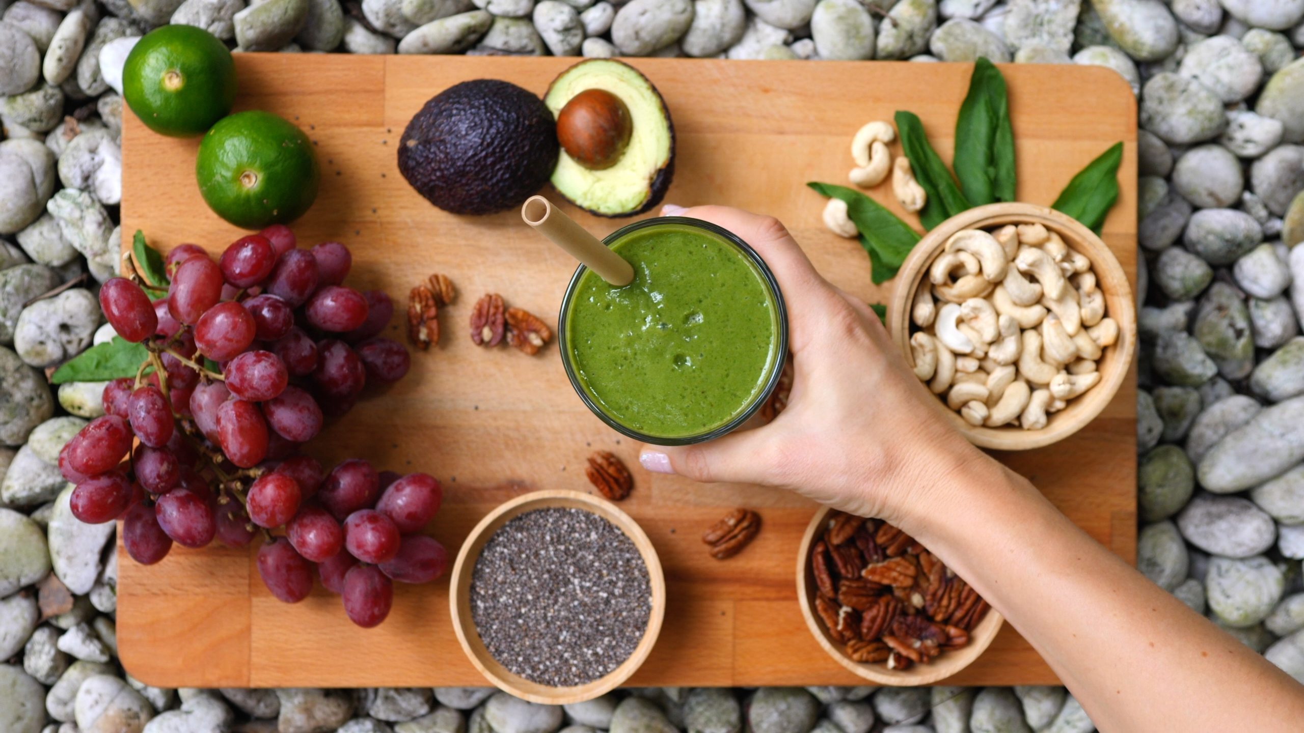 Top View Of Female Hand With Healthy Vegan Green Smoothie.