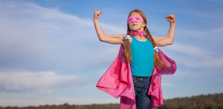 a female child wearing a pink cape
