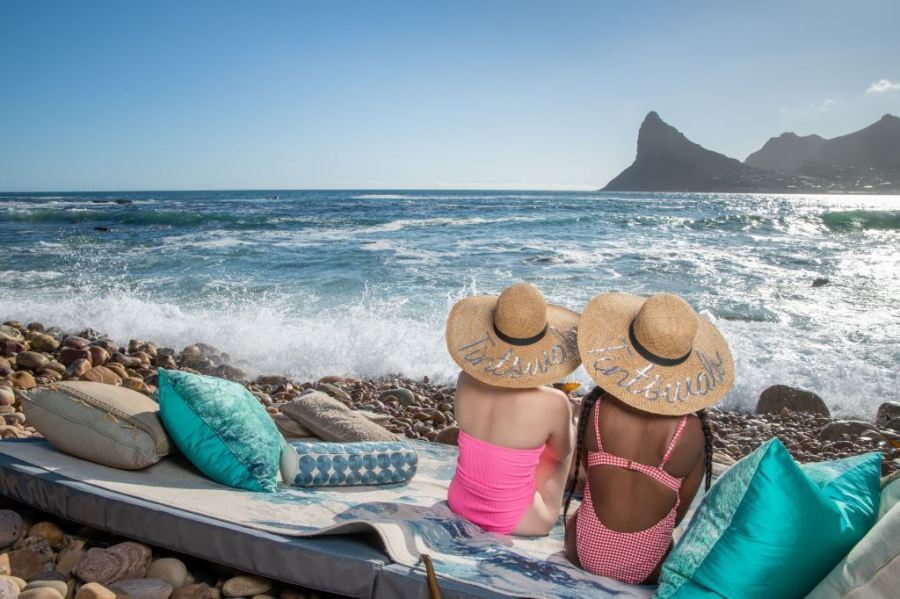 two women sitting on a beach