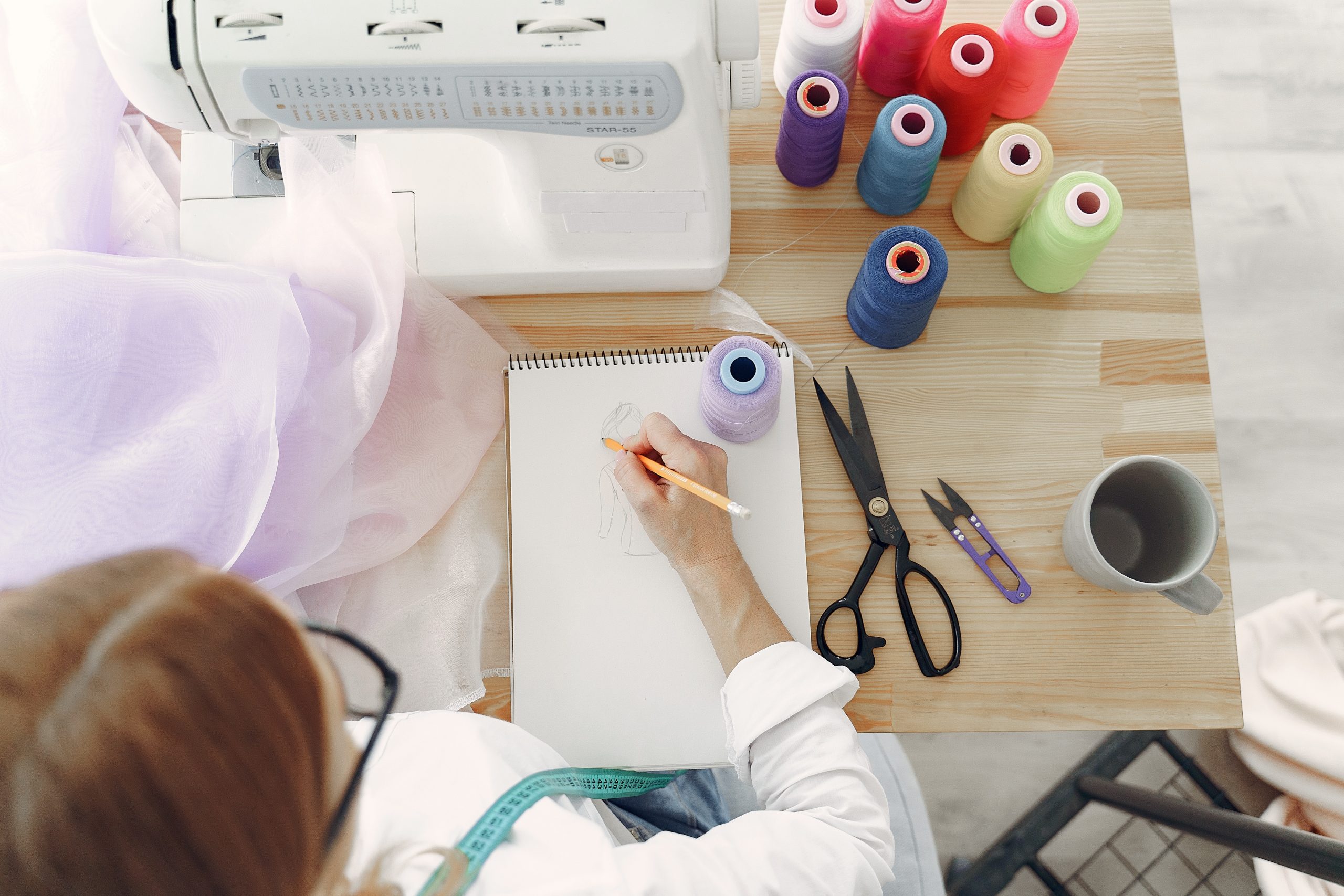 woman-in-white-long-sleeve-shirt-sketching-on-white-printer