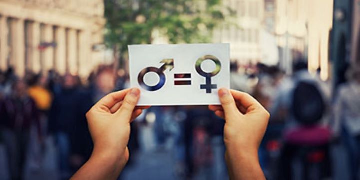 a women's hands holding up piece of white paper with gender symbols