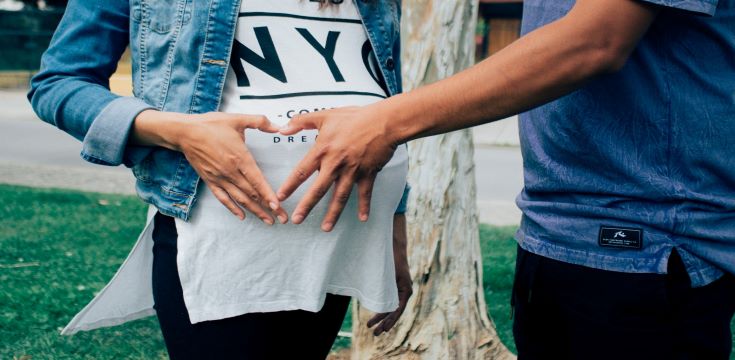 pregnant-woman-holding-her-tummy-together-with-a-man-beside