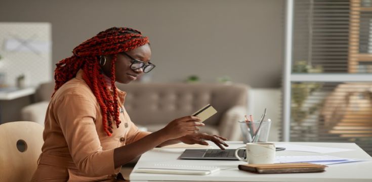 side-view-portrait-young-african-american-woman-holding-credit-card-while-enjoying-online-shopping-home-office-copy-space_236854-25261 (003)