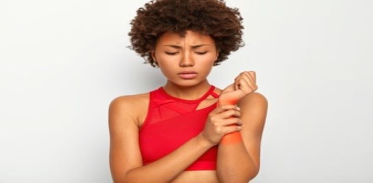 upset-displeased-woman-touches-injured-hand-shows-problematic-painful-zone-wrist-marked-with-red-dressed-casual-top-suffers-from-terrible-pain