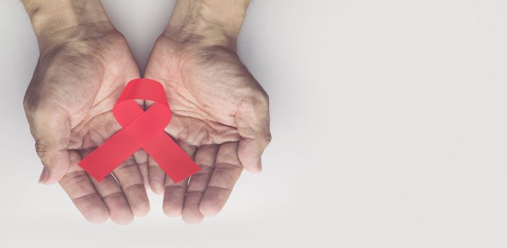 man-holding-red-aids-ribbon-hiv-aids-aging-awareness-month-concept (002)