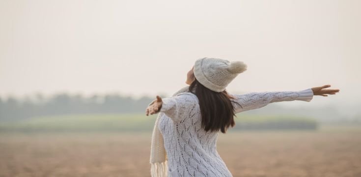 happy-woman-enjoying-idyllic-nature-celebrating-freedom-rising-her-arms