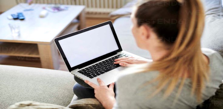 high-angle-view-of-woman-using-laptop-while-sitting-on-sofa-at-home-MMIF00239
