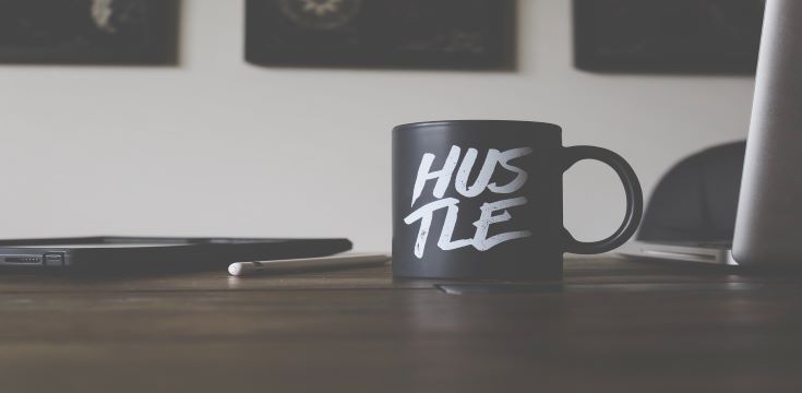 white-and-black-hustle-printed-ceramic-mug-on-table-photo
