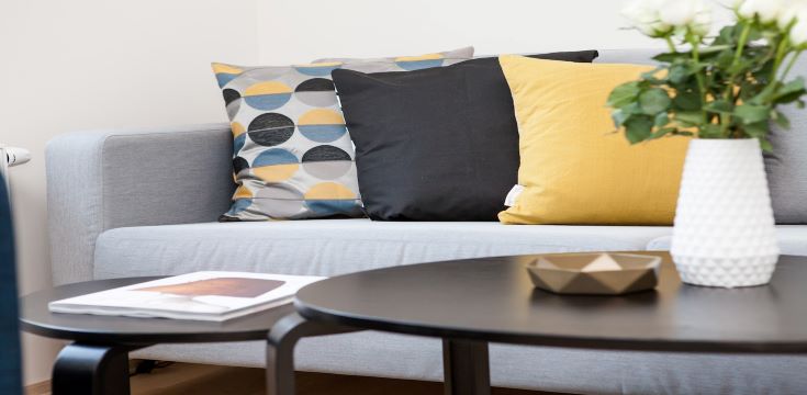 centerpiece-on-coffee-table-beside-sofa-with-three-pillows