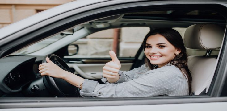 beautiful-young-latin-woman-driving-her-brand-new-car-showing-her-thumb-up