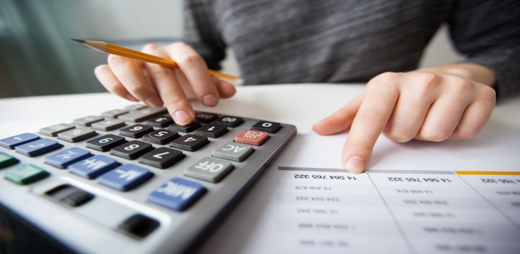 closeup-accountant-hands-counting-calculator