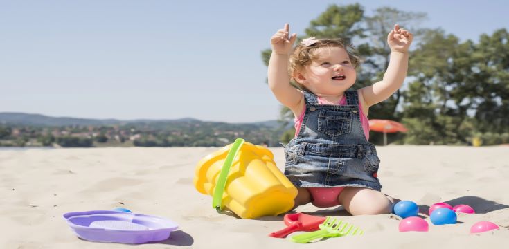 adorable-little-girl-playing-beach-with-colorful-balls-plastic-toys