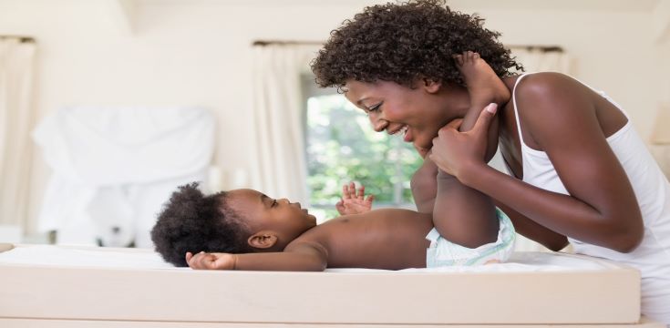 happy-mother-with-baby-girl-on-changing-table