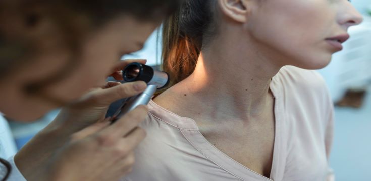 dermatologist-latex-gloves-holding-dermatoscope-while-examining-attractive-patient-with-skin