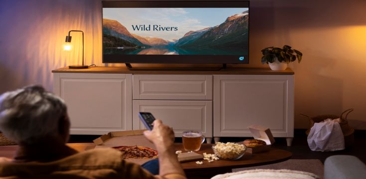 man-enjoying-food-while-being-home-alone-watching-tv