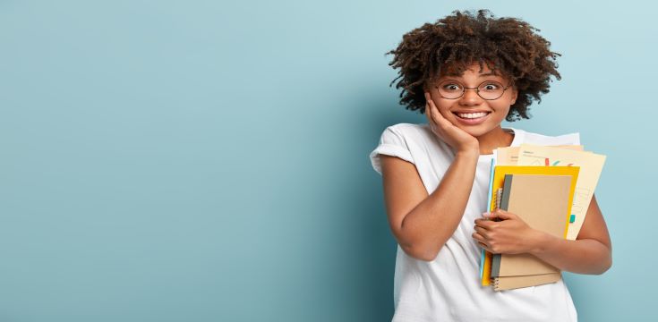pleasant-looking-afro-american-woman-holds-notepads-papers-studies-college-glad-finish-studying