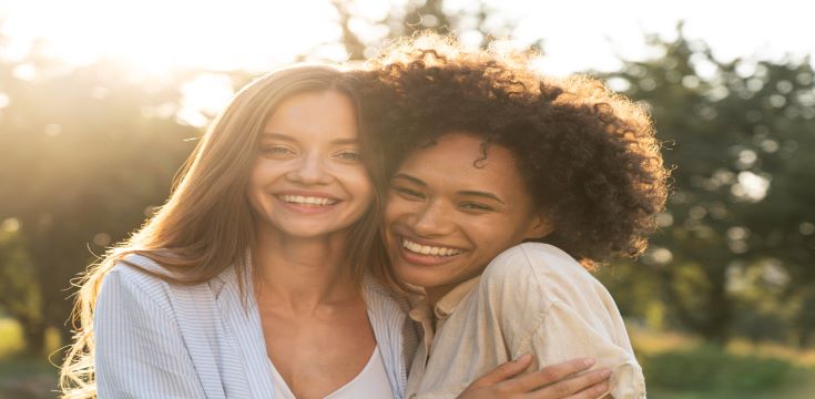 female-friends-smiling-hugging-each-other