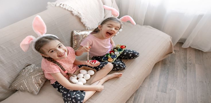 little-sisters-bunny-ears-paint-easter-eggs-sofa-home