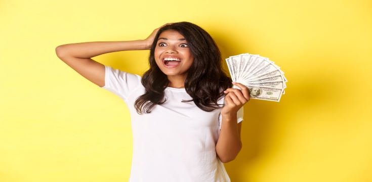 lucky-africanamerican-girl-looking-excited-upper-left-corner-holding-money