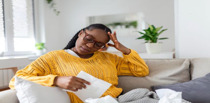 portrait-attractive-woman-sitting-sofa-home-with-headache-feeling-pain-with-expression-being-unwell-upset-depressed-woman-lying-couch-feeling-strong-headache-migraine