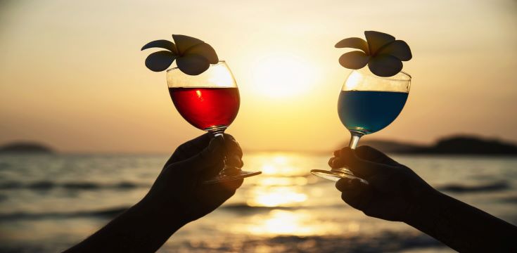 silhouette-couple-hand-holding-cocktail-glass-decoration-with-plumeria-flower-with-beach-happy-relax-celebration-vacation-sea-nature-concept