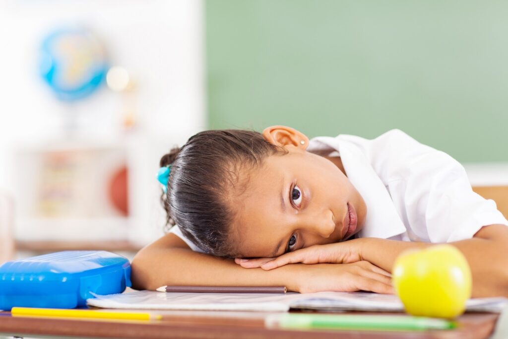 Primary,Schoolgirl,Resting,On,Desk