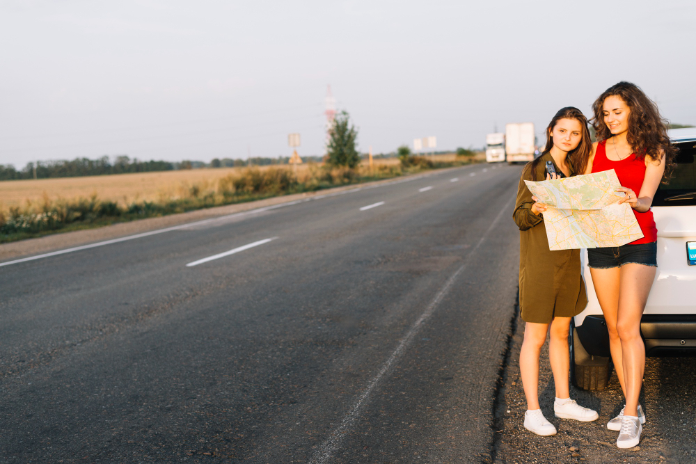 women-standing-near-white-car-with-map
