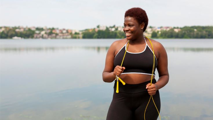 smiley-woman-outdoors-taking-break-from-jumping-rope