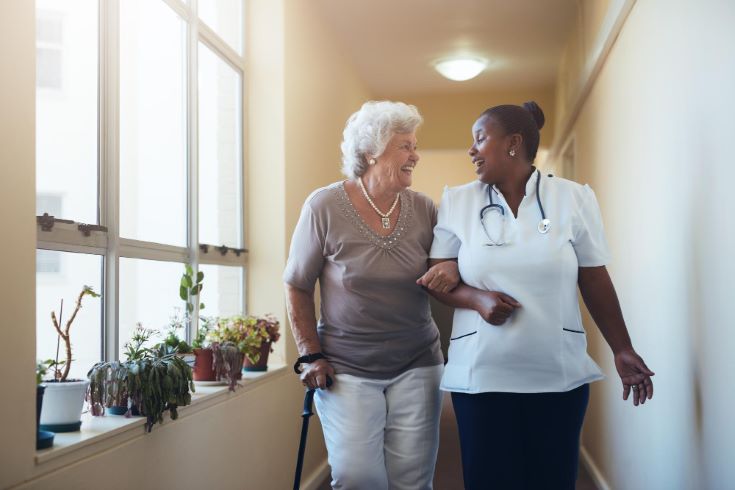 portrait-smiling-healthcare-worker-walking-talking-with-senior-woman-happy-elder-woman
