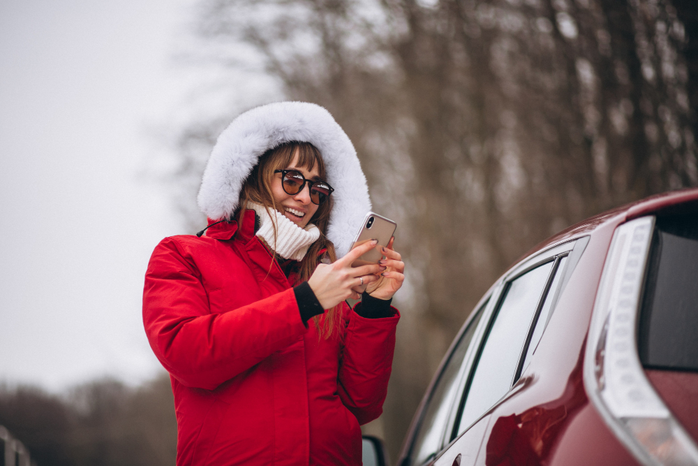 woman-happy-talking-phone-outside-by-car-winter