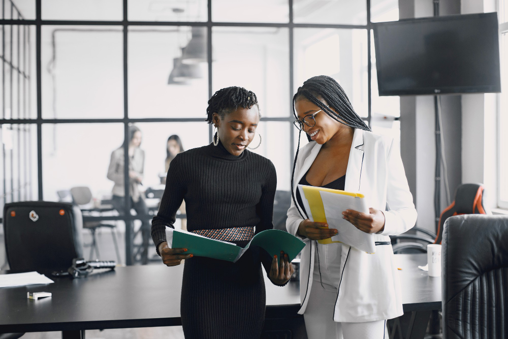 business-women-talking-near-desk-during-coffee-break-hallway-big-corporation