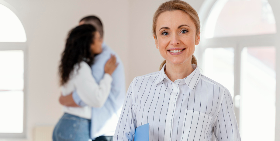 front-view-smiley-female-realtor-with-young-couple-embracing-background