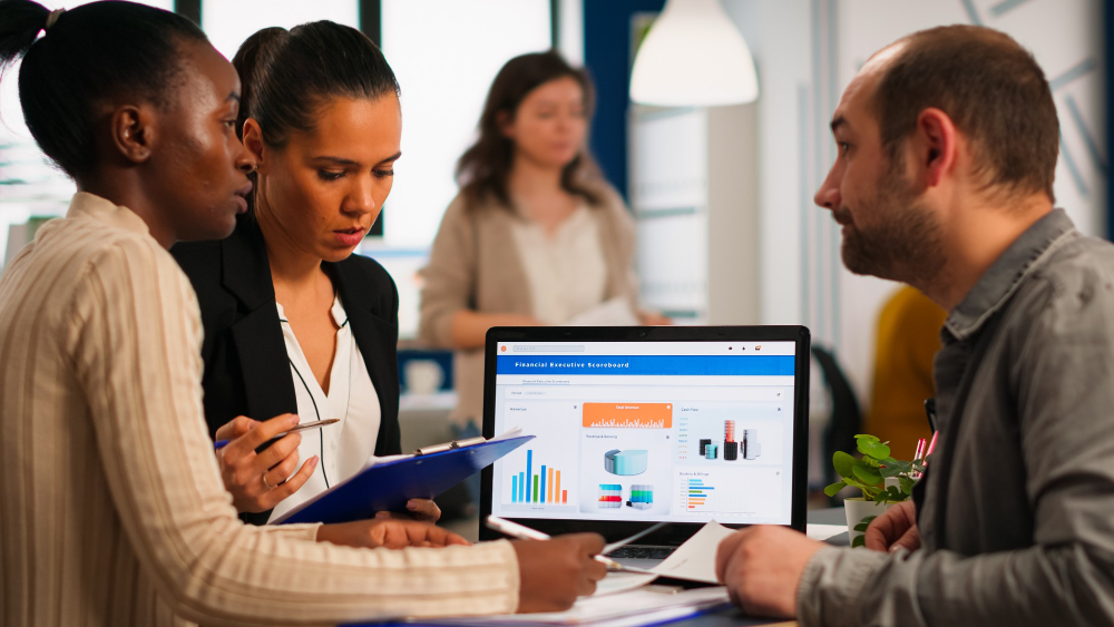 busy-multicultural-diverse-employees-analysing-annual-financial-statistics-sitting-desk-front-laptop-holding-documents-searching-business-solutions-team-businesspeople-working-company